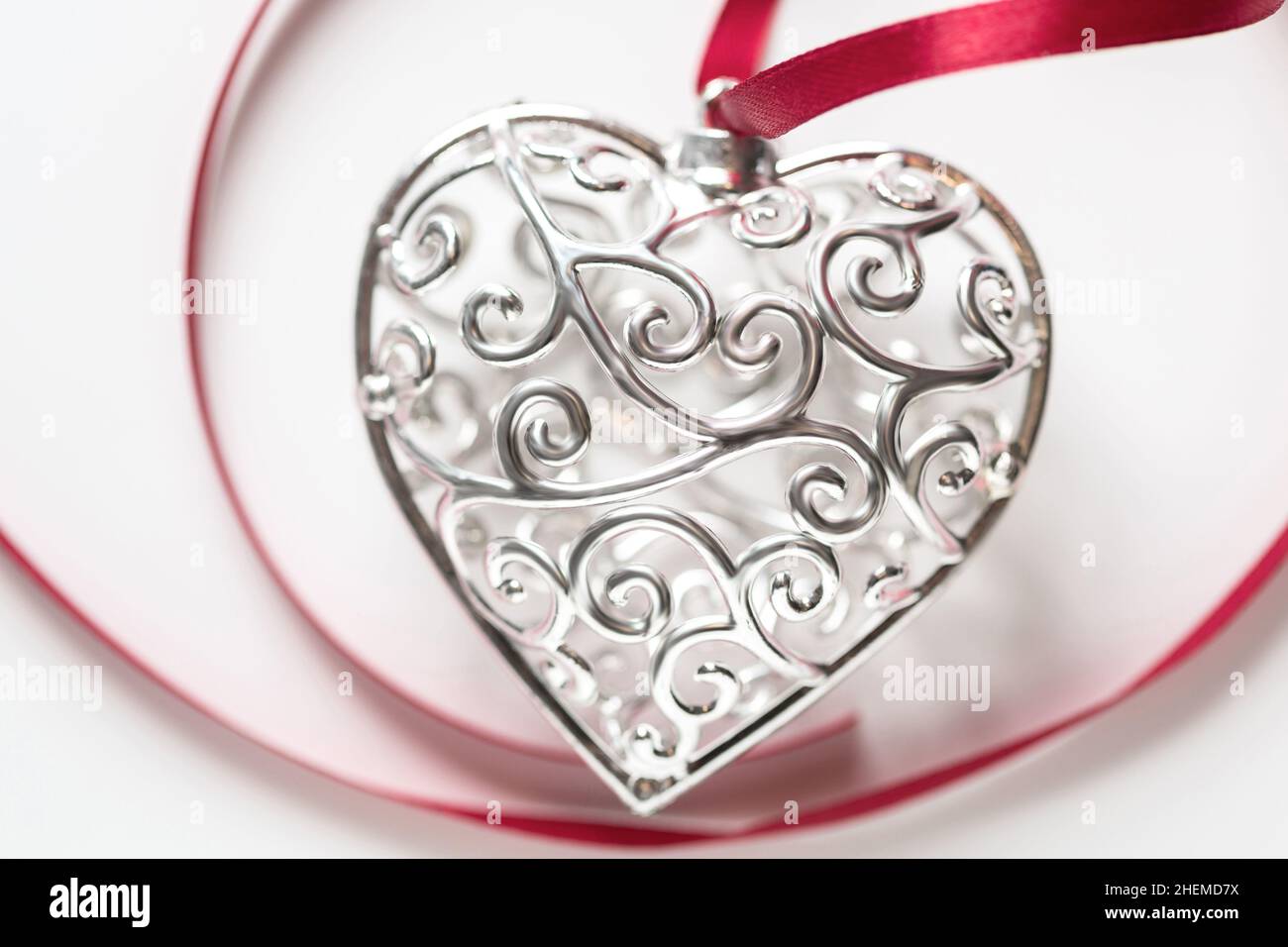 Saint Valentine day greeting card, beautiful silver heart with ribbon on white background Stock Photo