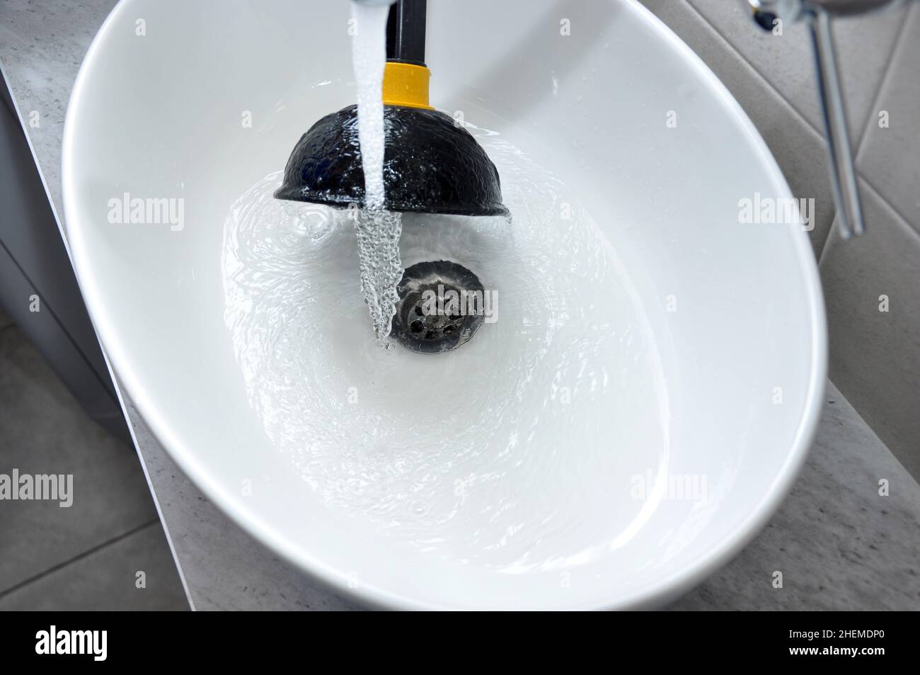 Clogged sink in house unclog the blockage with sink plunger Stock