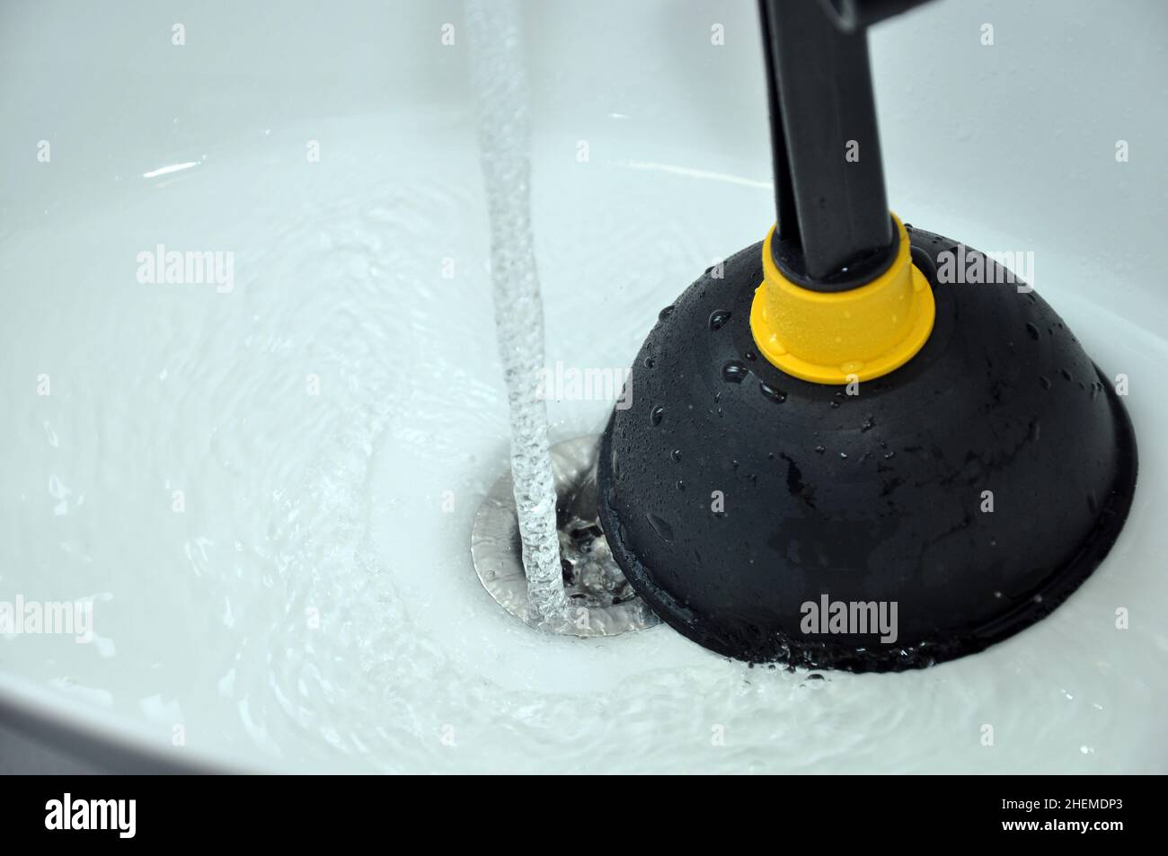 Clogged sink in house unclog the blockage with sink plunger Stock