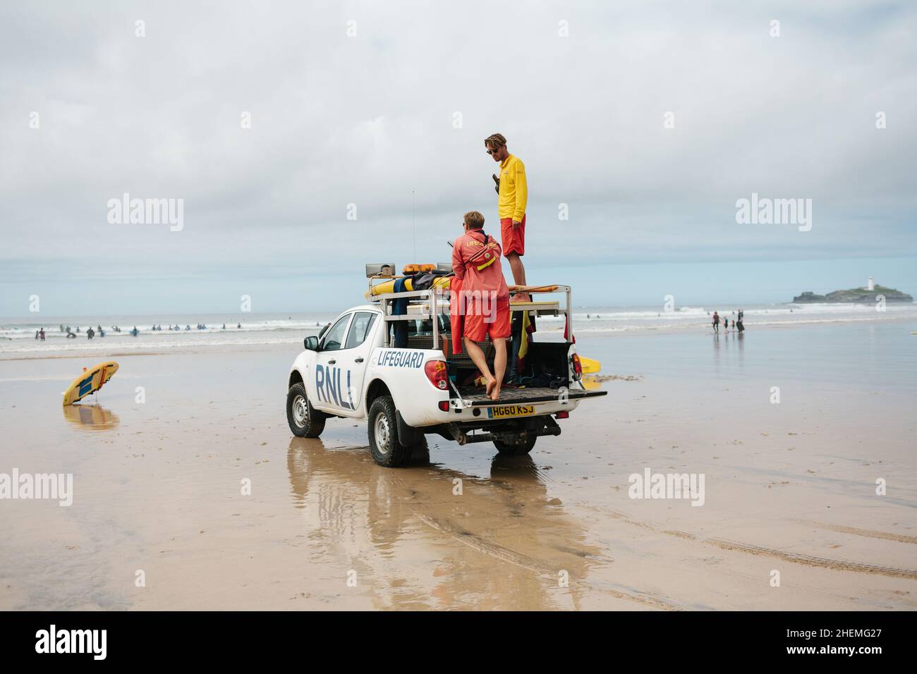 RNLI Lifeguards lookout for bathers and surfers safety from the high vantage point of their 4x4 on the beach at Gwithian near St Ives, Cornwall. Stock Photo
