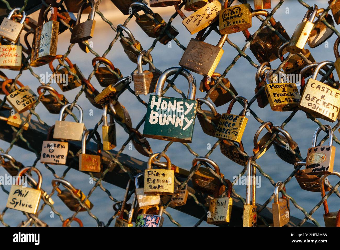 Padlocks with couples names on declaring everlasting love, locked onto the mesh fence of Post des Arts in Paris, France. Stock Photo