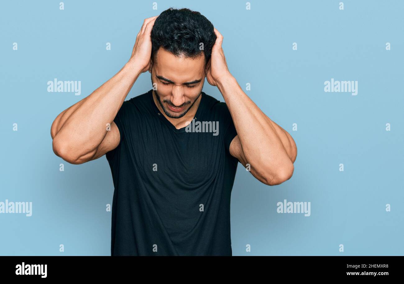 Hispanic man with beard wearing casual black t shirt suffering from ...