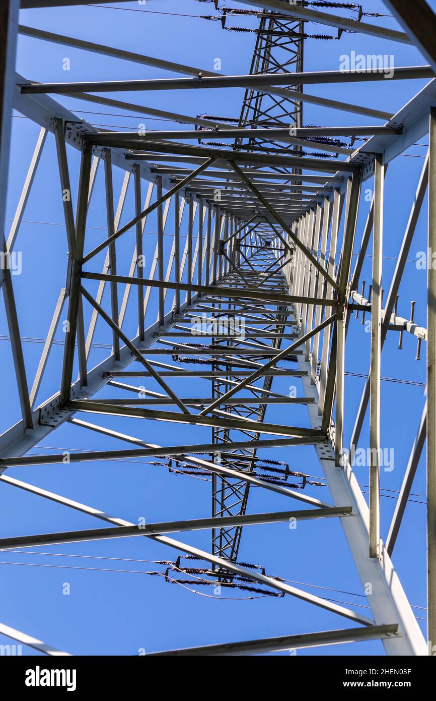 gray electric pylon under clear blue sky Stock Photo