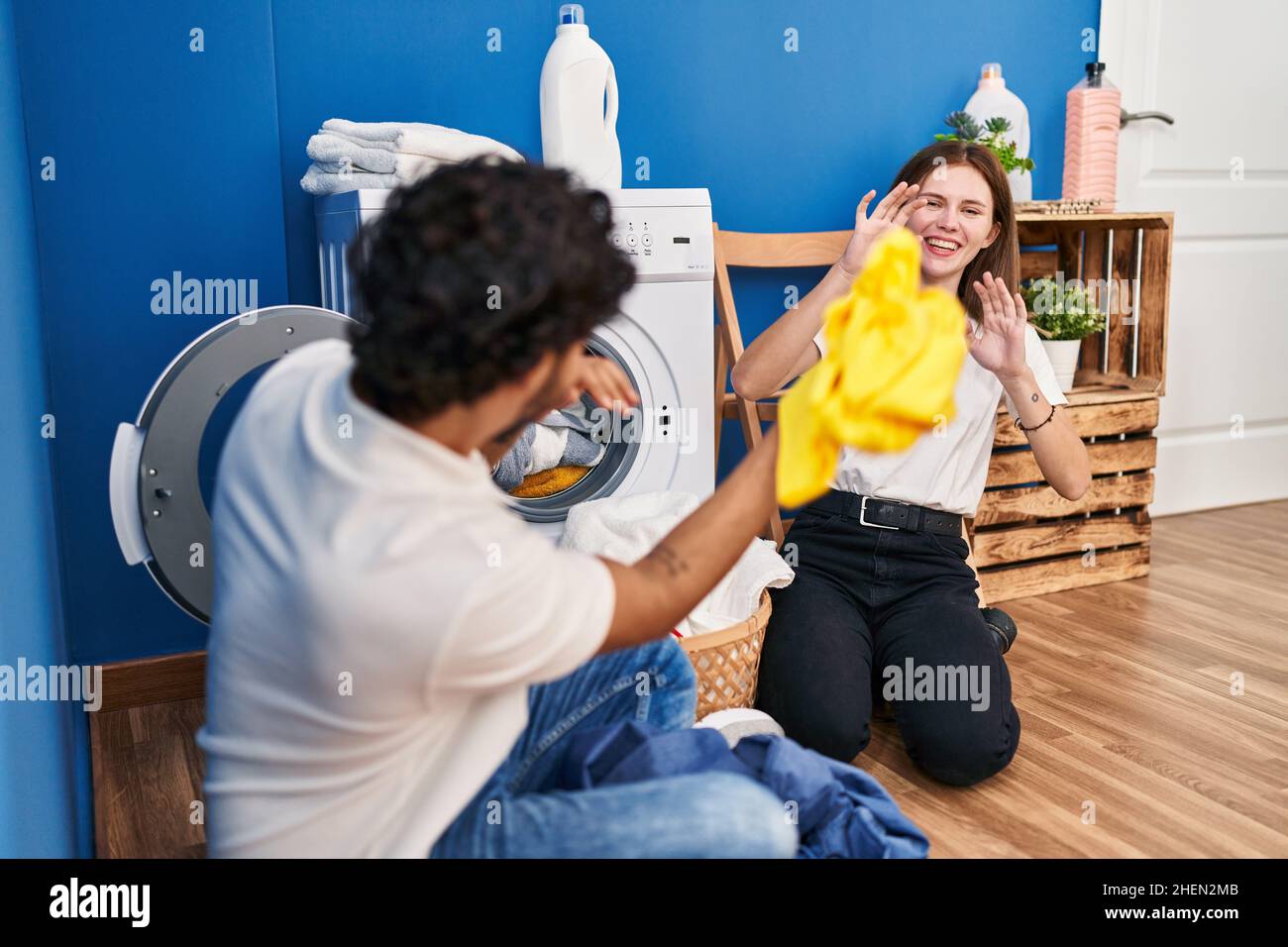Using Clean Clothes Man and woman couple smiling confident playing with cleaning clothes at ...