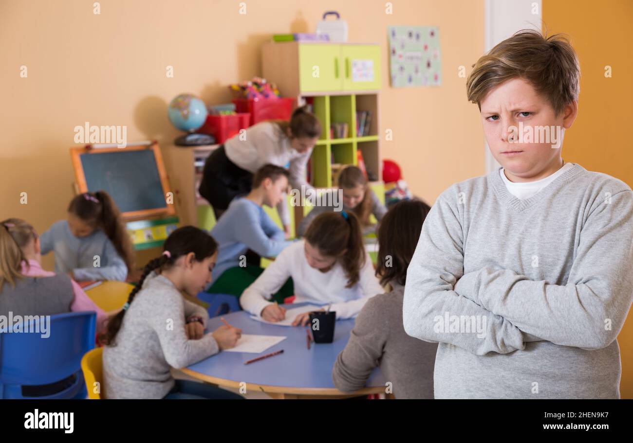 Boy standing, elementary age children drawing at class Stock Photo - Alamy