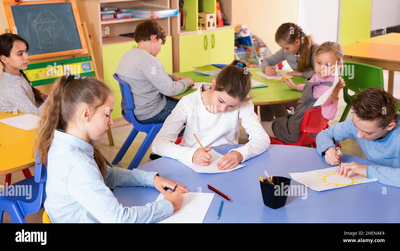 Portrait of young teacher woman at lesson with diligent school kids ...