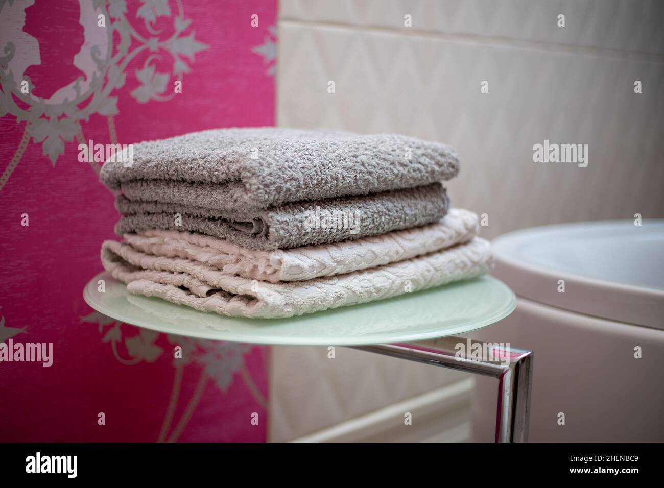 A stack of towels on a shelf dryer for things in the bathroom Stock