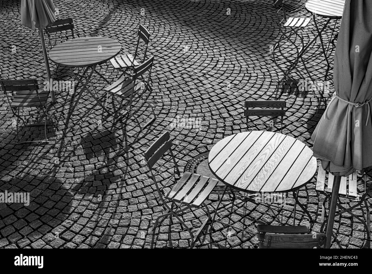 Outdoor German cafe seating with round tables and wooden  chairs Stock Photo