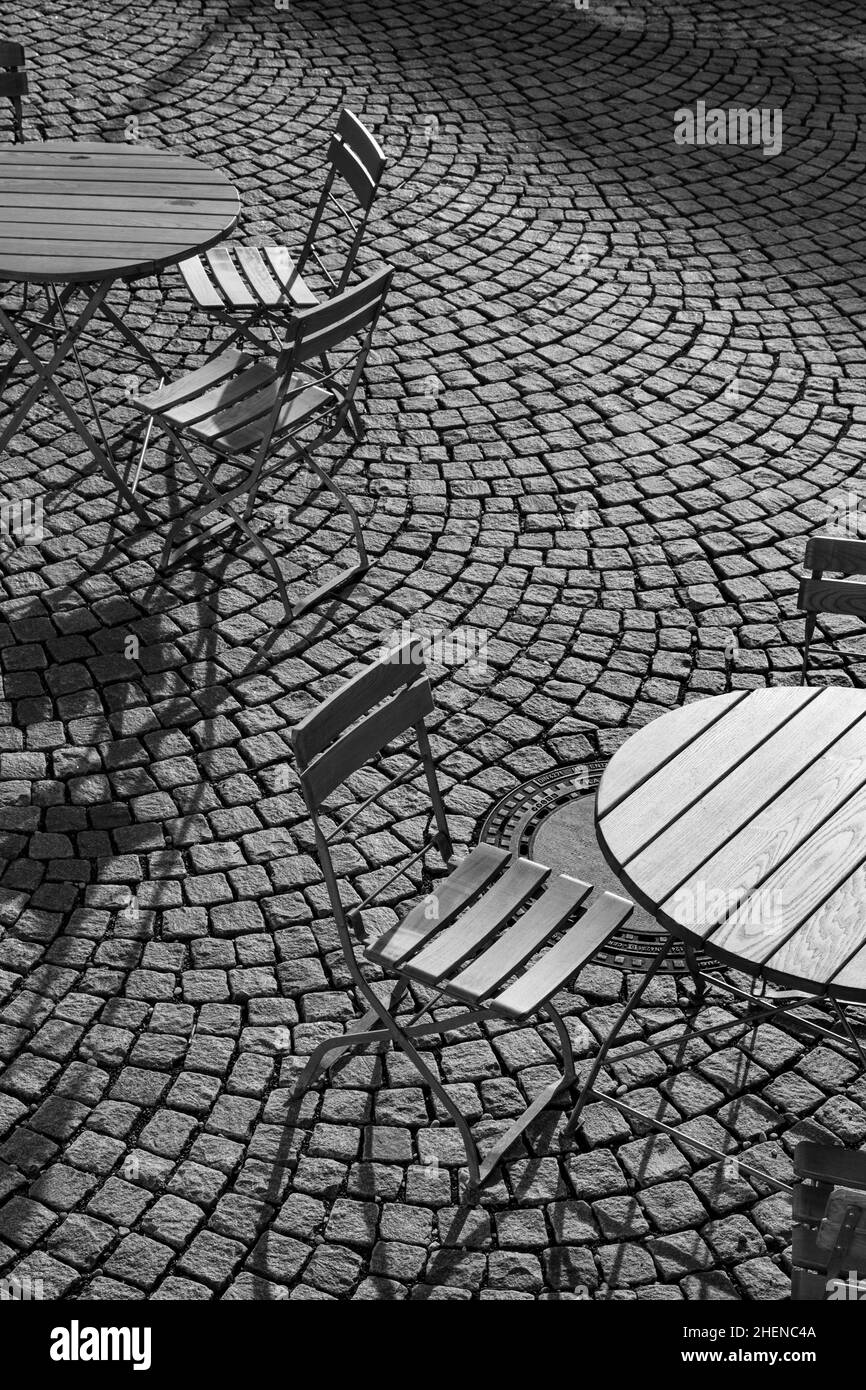 Outdoor German cafe seating with round tables and wooden  chairs Stock Photo
