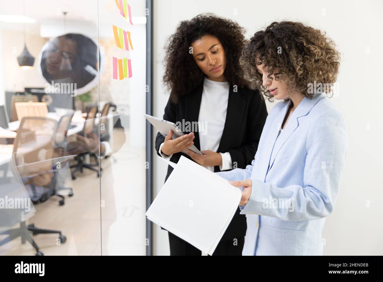 Multicultural coworkers using white board and doing brainstorming together. Co-working concept Stock Photo