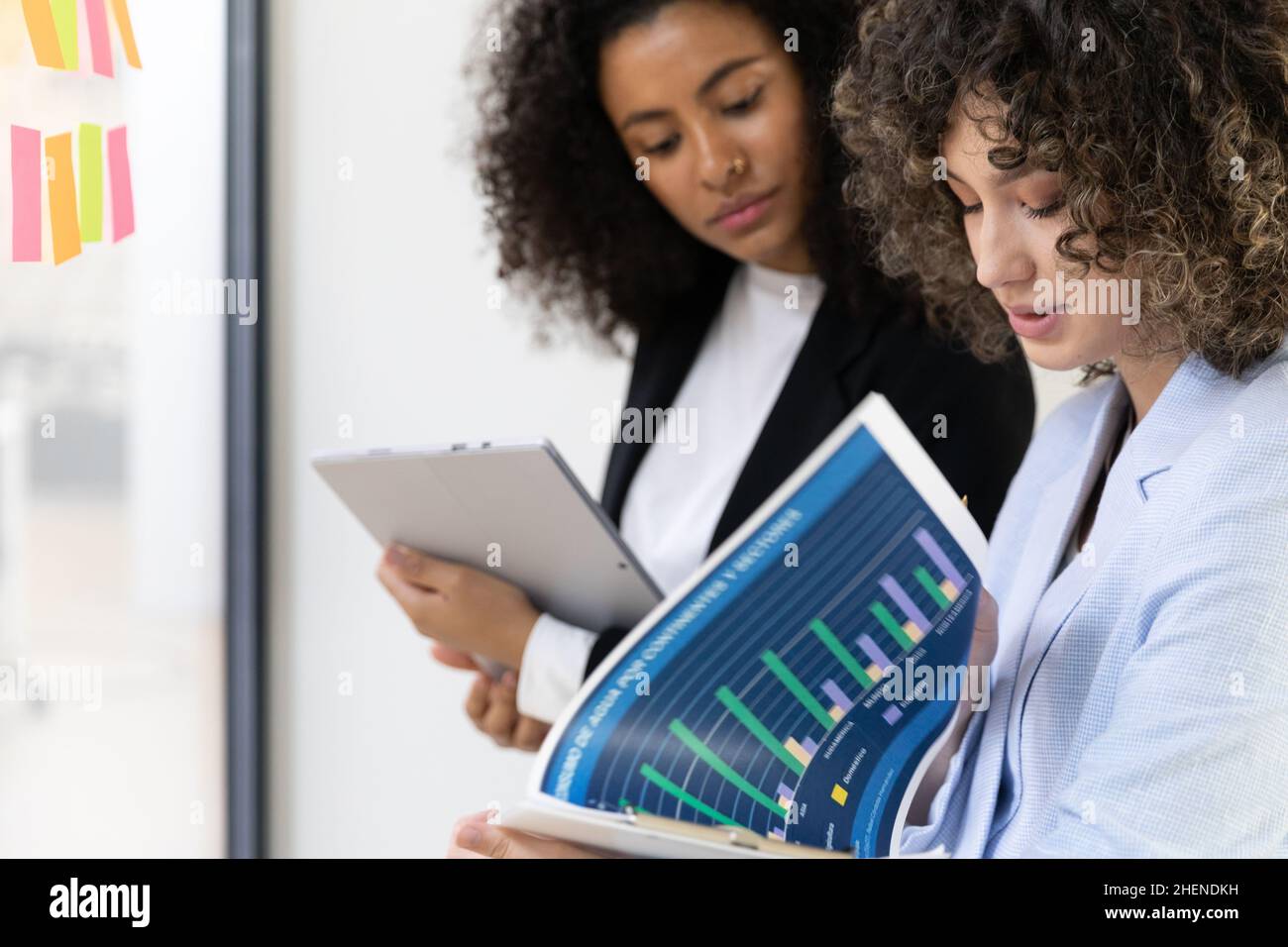 Multicultural coworkers using white board and doing brainstorming together. Co-working concept Stock Photo