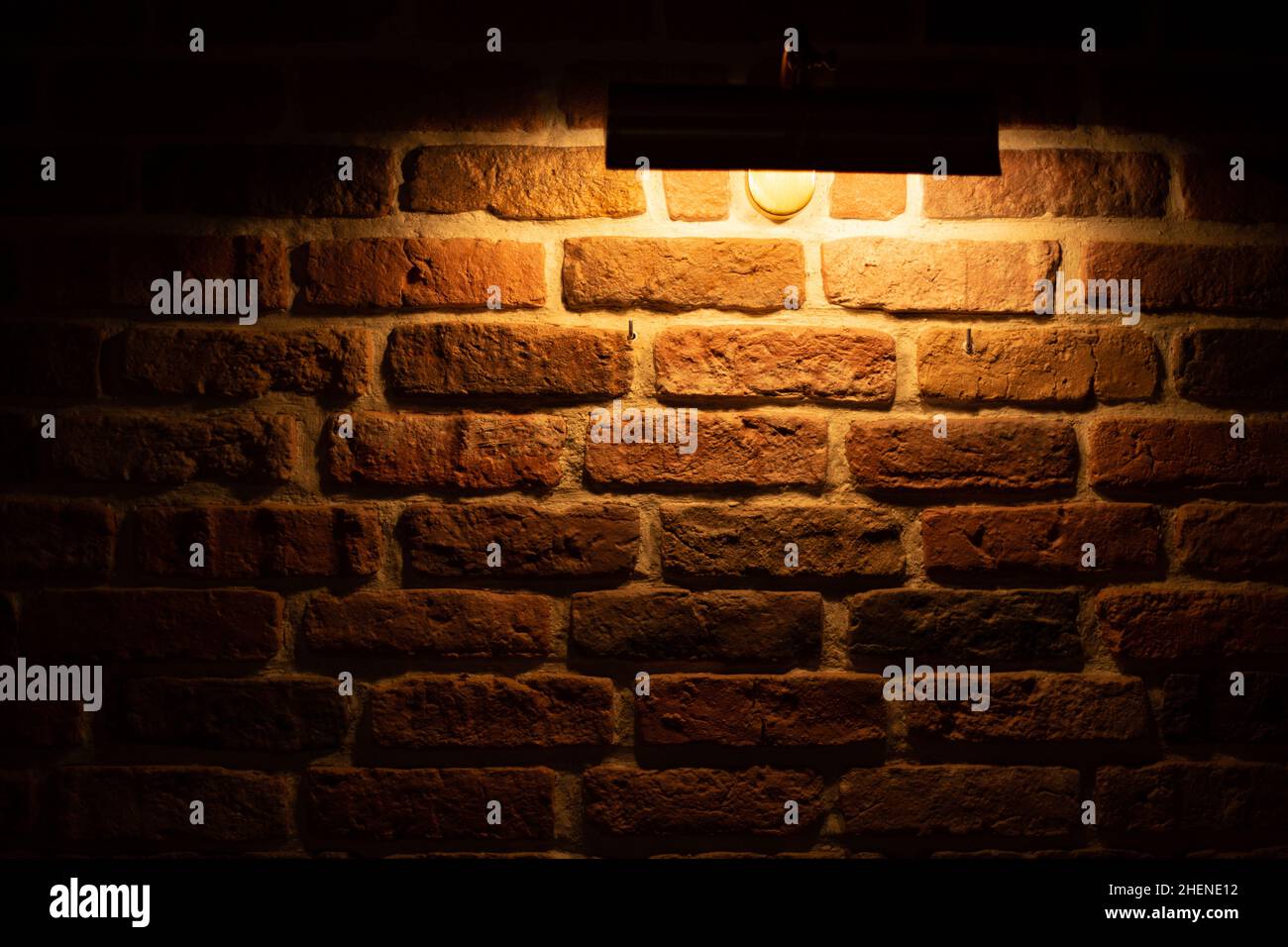 Brick wall illuminated by warm light from a lamp Stock Photo - Alamy