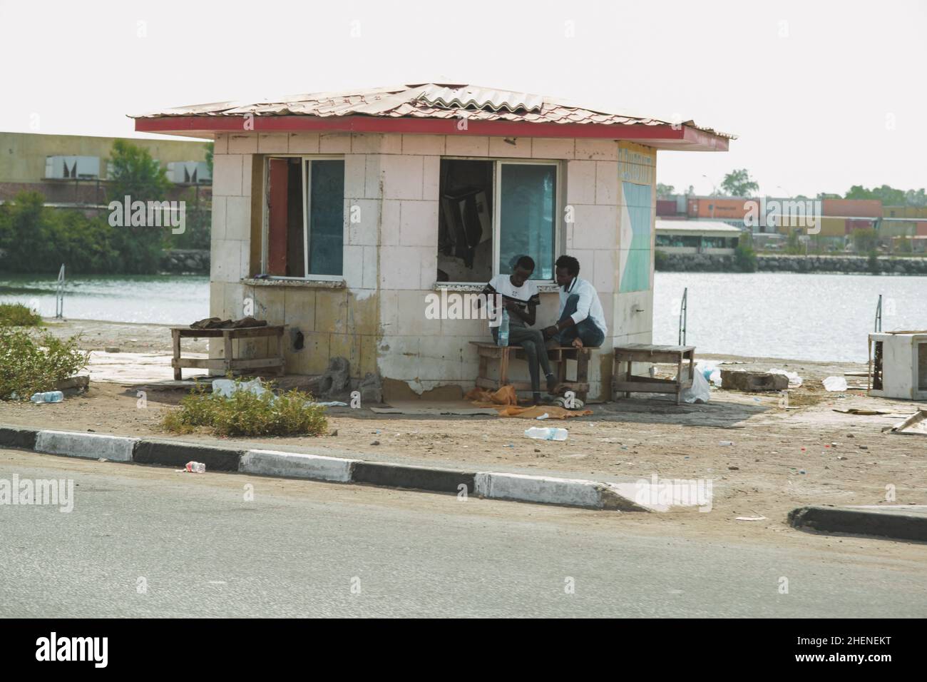 Djibouti, Djibouti - May 21, 2021: Two Djiboutians men sitting under an old shack . Editorial shot in Djibouti. Stock Photo