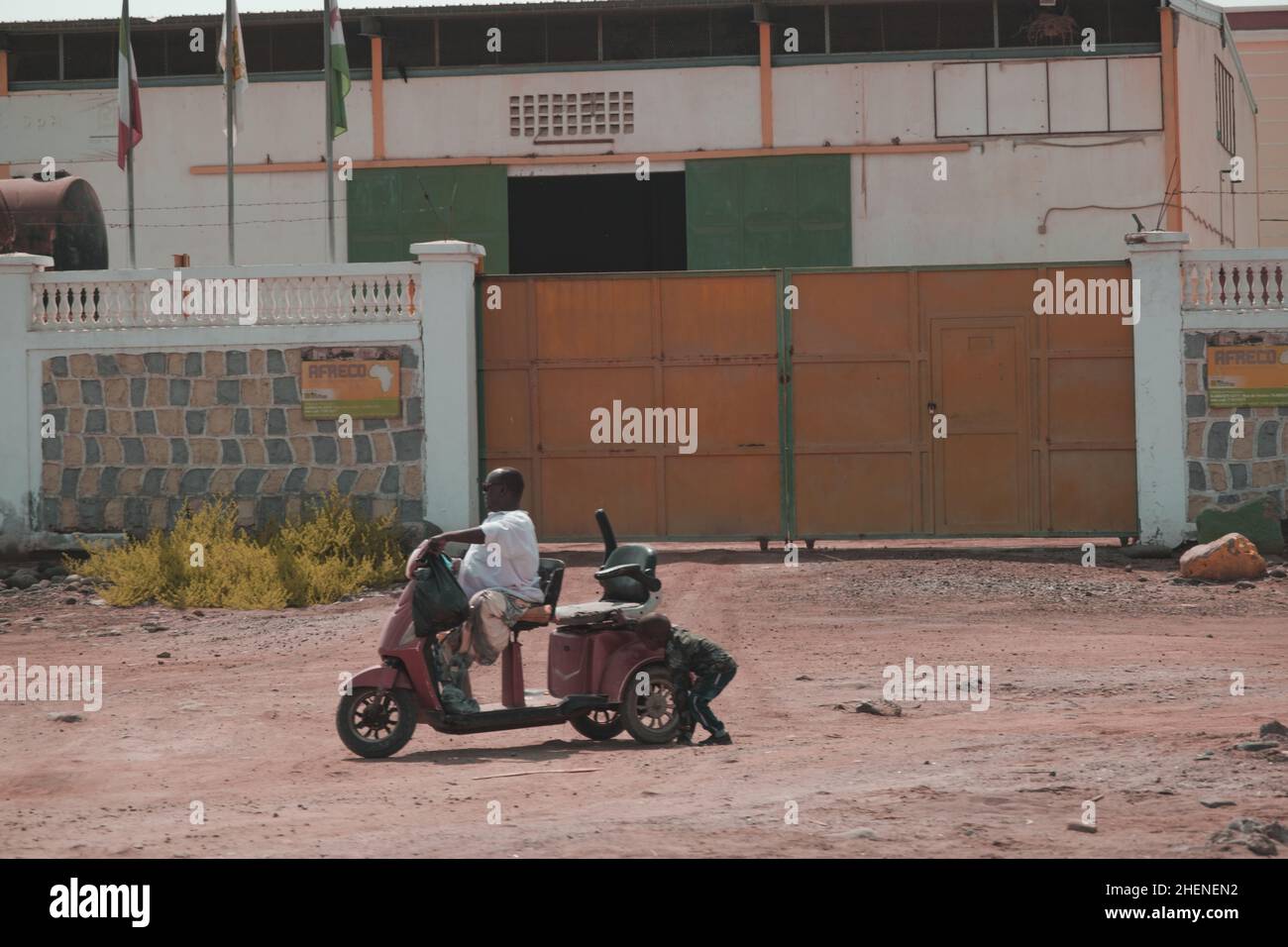 Djibouti, Djibouti - May 21, 2021: A Djiboutian disabled man and a Djiboutian child with motorcycle. Editorial shot in Djibouti Stock Photo