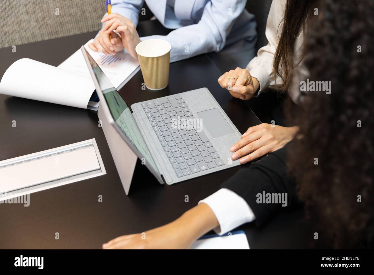Unrecognized female office workers using digital tablet during a meeting. Stock Photo