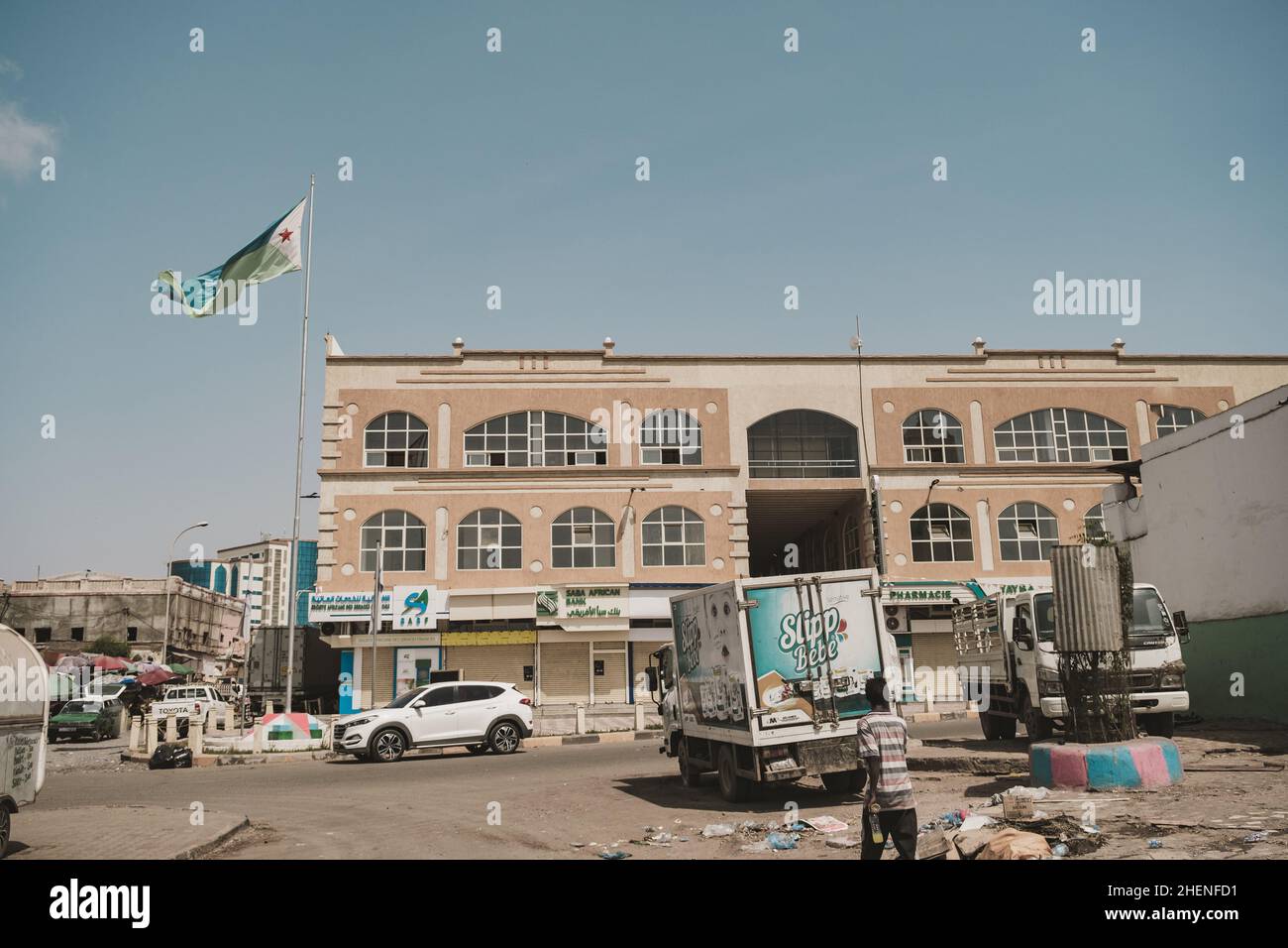 Djibouti, Djibouti - May 21, 2021: Djibouti flag and a building in Djibouti. A street in Djibouti. Editorial shot in Djibouti. Stock Photo
