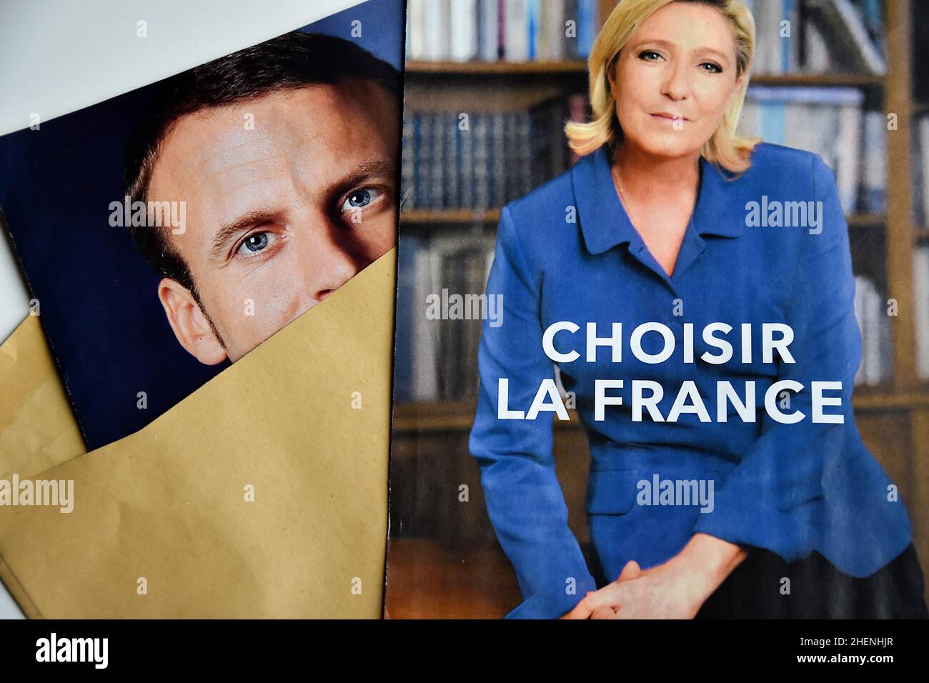 France. 10th Jan, 2022. In this photo illustration, Marine Le Pen and Emmanuel Macron's ballot papers and election posters are seen displayed. While he is not yet officially a candidate for his re-election, the President of the French Republic, Emmanuel Macron is leading the polls for the presidential elections of 2022 with 27% of the voting intentions in front of the candidate of the National Rally (RN) Marine Le Pen (17.5%). The first round of the election of the President of the Republic will take place on April 10, 2022. Credit: SOPA Images Limited/Alamy Live News Stock Photo