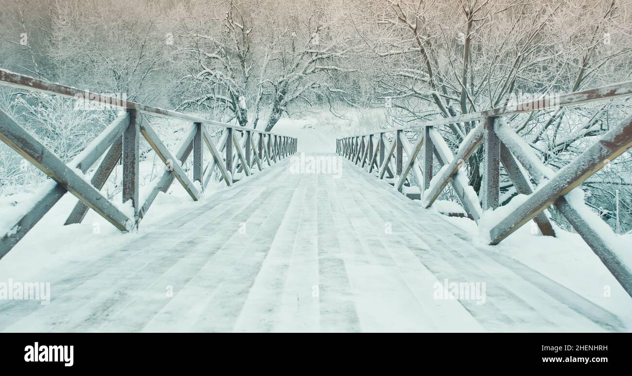 Winter, wooden pedestrian bridge in park in nature. Winter landscape Stock Photo