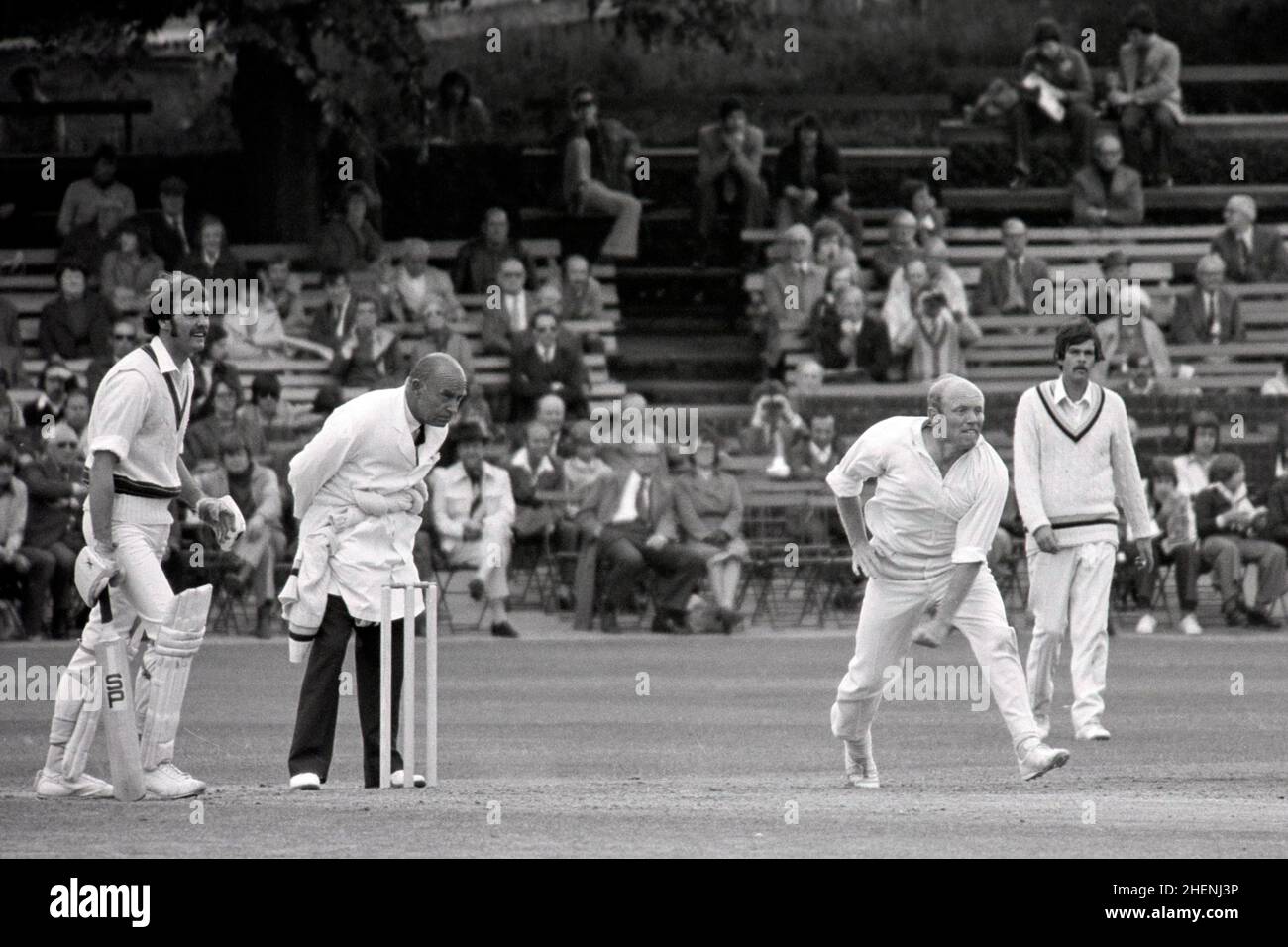 Fred Swarbrook bowling for Derbyshire, Derbyshire vs. Australians, Queens Park, Chesterfield, Derbyshire, England 29th,30th June & 1st July 1977. Non-striking batsman is Richie Robinson (Aus.) Geoff Miller is on the right, in front of pavilion. Umpire is “Sam” Cook. Stock Photo