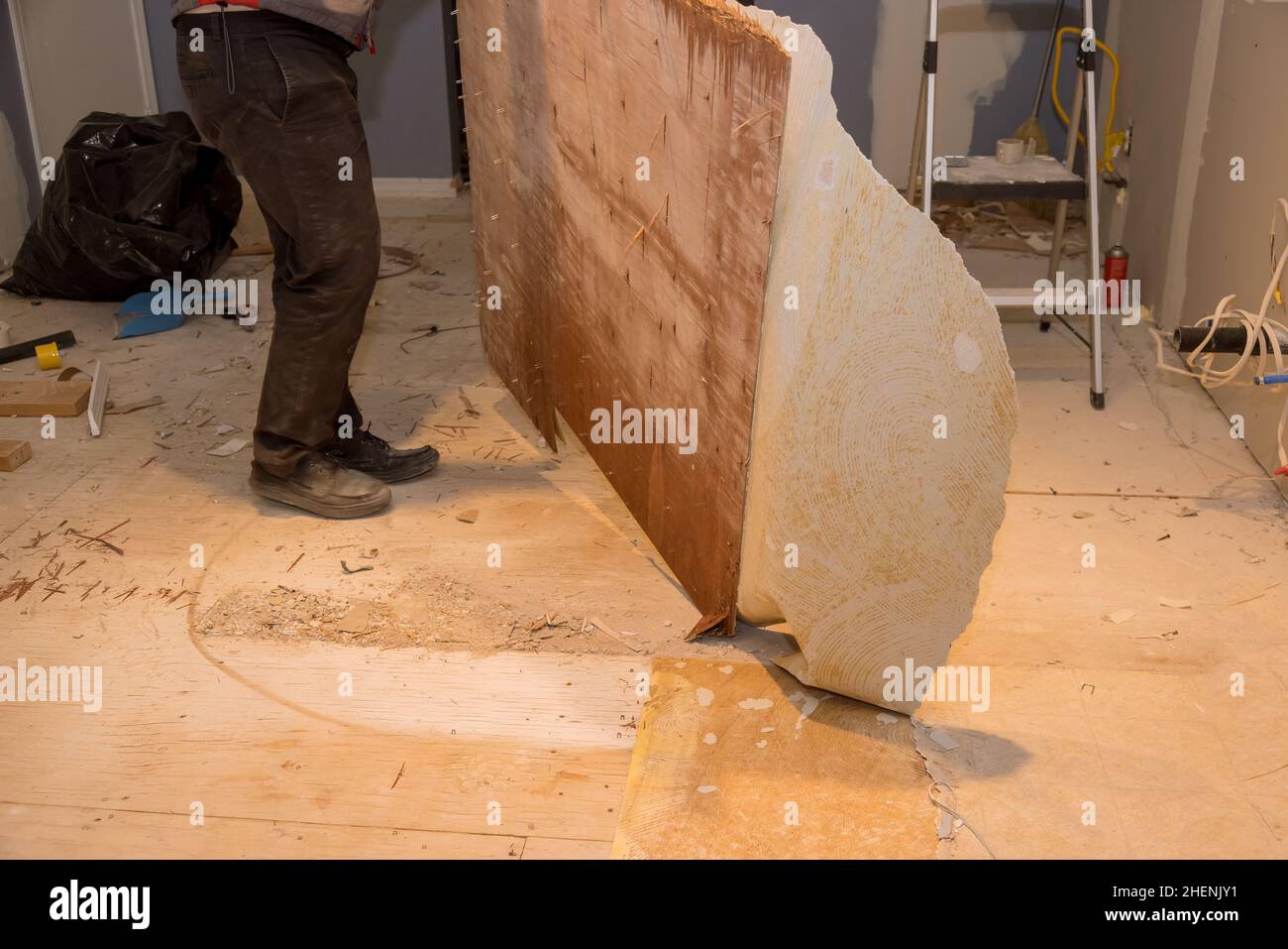 Construction worker remove old laminate floor for repairing and installing parquet in house Stock Photo