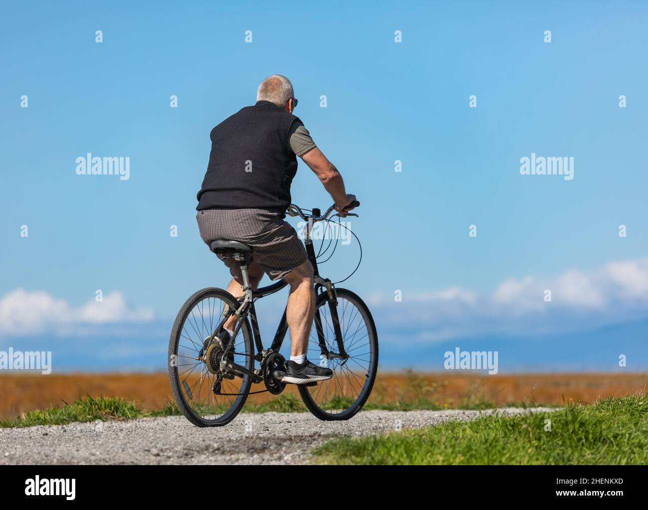 Senior man on cycle ride in countryside in Canada. Travel photo, selective focus, copy space for text, concept photo active aging Stock Photo