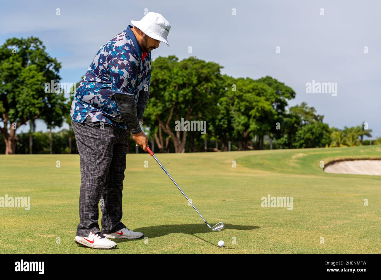 Golf player teeing off. Man hitting golf ball from tee box at Golf Club