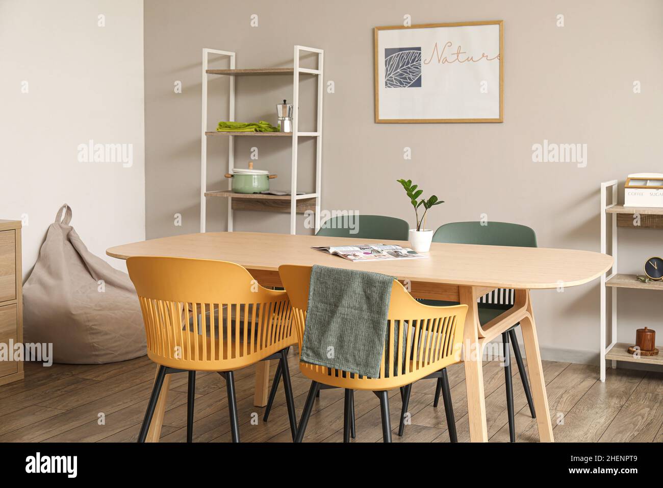 Interior of light dining room with table and shelving units Stock Photo ...