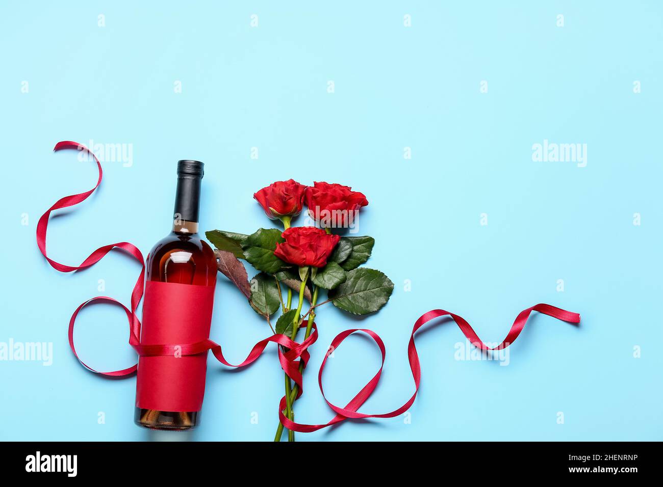 Bottle of wine with rose flowers on color background Stock Photo Alamy