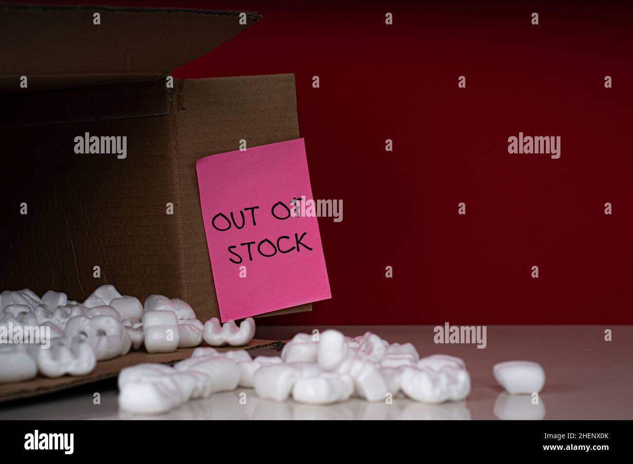 Business concept. Layout of packing peanuts, box and note with text OUT OF STOCK. Stock Photo