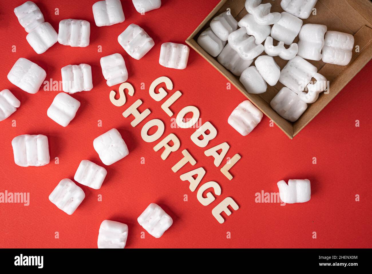 Business concept. Layout of packing peanuts, box and wood alphabet with text GLOBAL SHORTAGE. Stock Photo