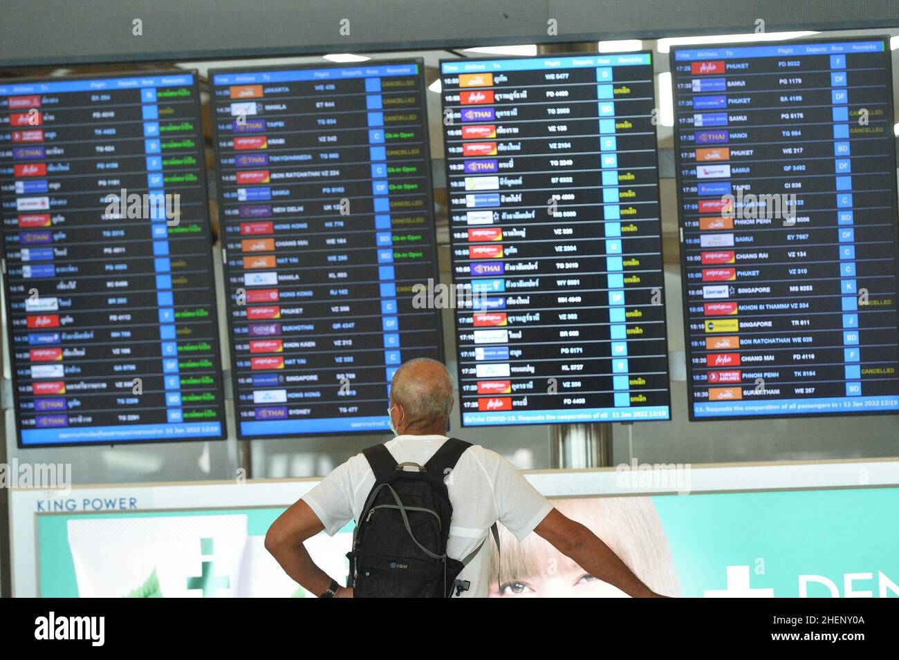 BANGKOK, Jan. 12, 2022 (Xinhua) -- A traveller looks at a flight schedule at the Suvarnabhumi International Airport in Bangkok, Thailand, Jan. 11, 2022. Due to concerns about a new wave of COVID-19 outbreak, Thailand halted the quarantine-free travel scheme from Dec. 22, 2021 and most of its Sandbox Program, which enables quarantine-free entry while requiring visitors to stay in a specific destination for seven days with free movement during their stay, except for the resort island of Phuket. According to the Center for COVID-19 Situation Administration, from Jan. 11 onwards, Tha Stock Photo