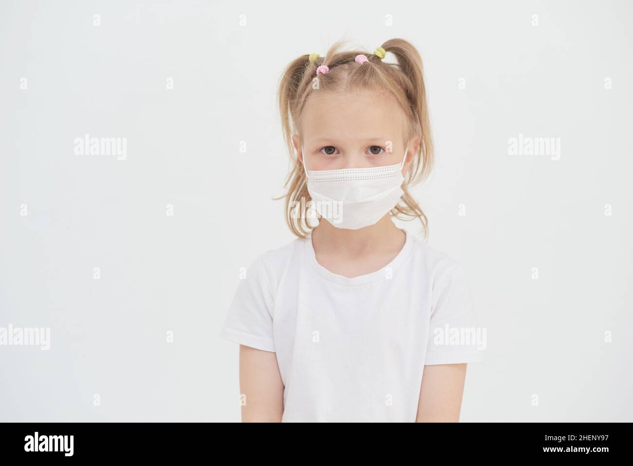 Portrait of a little girl in a medical protective mask to prevent ...