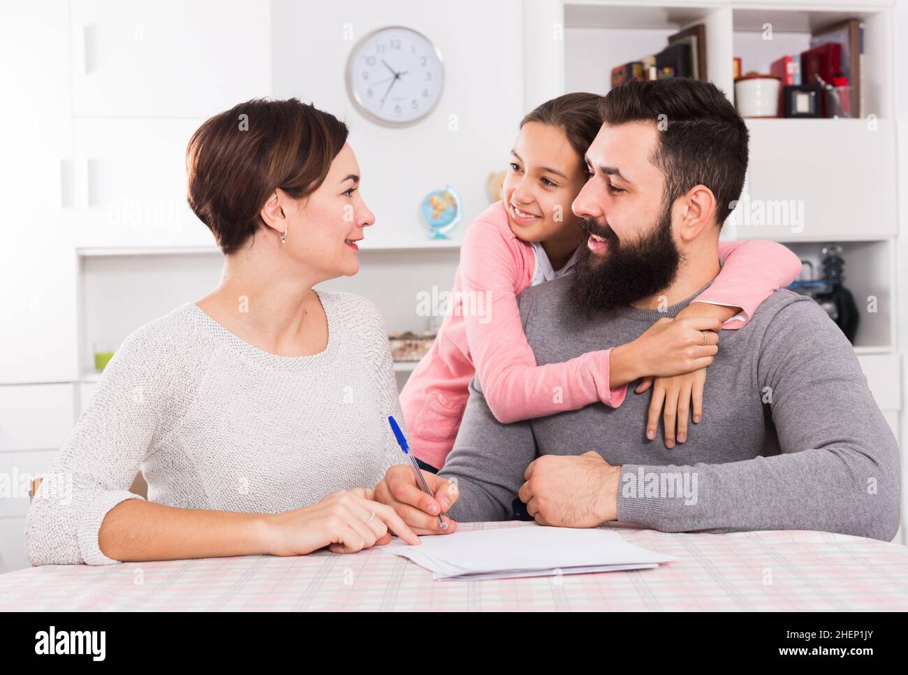 Parents signing property papers Stock Photo