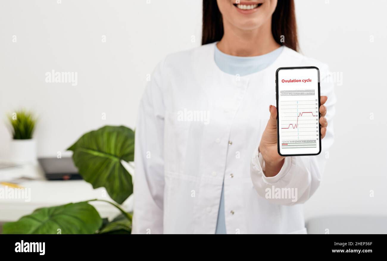 Smiling female doctor with arms crossed standing at her doctor office and looking at camera. medical occupation concept with space for text Stock Photo