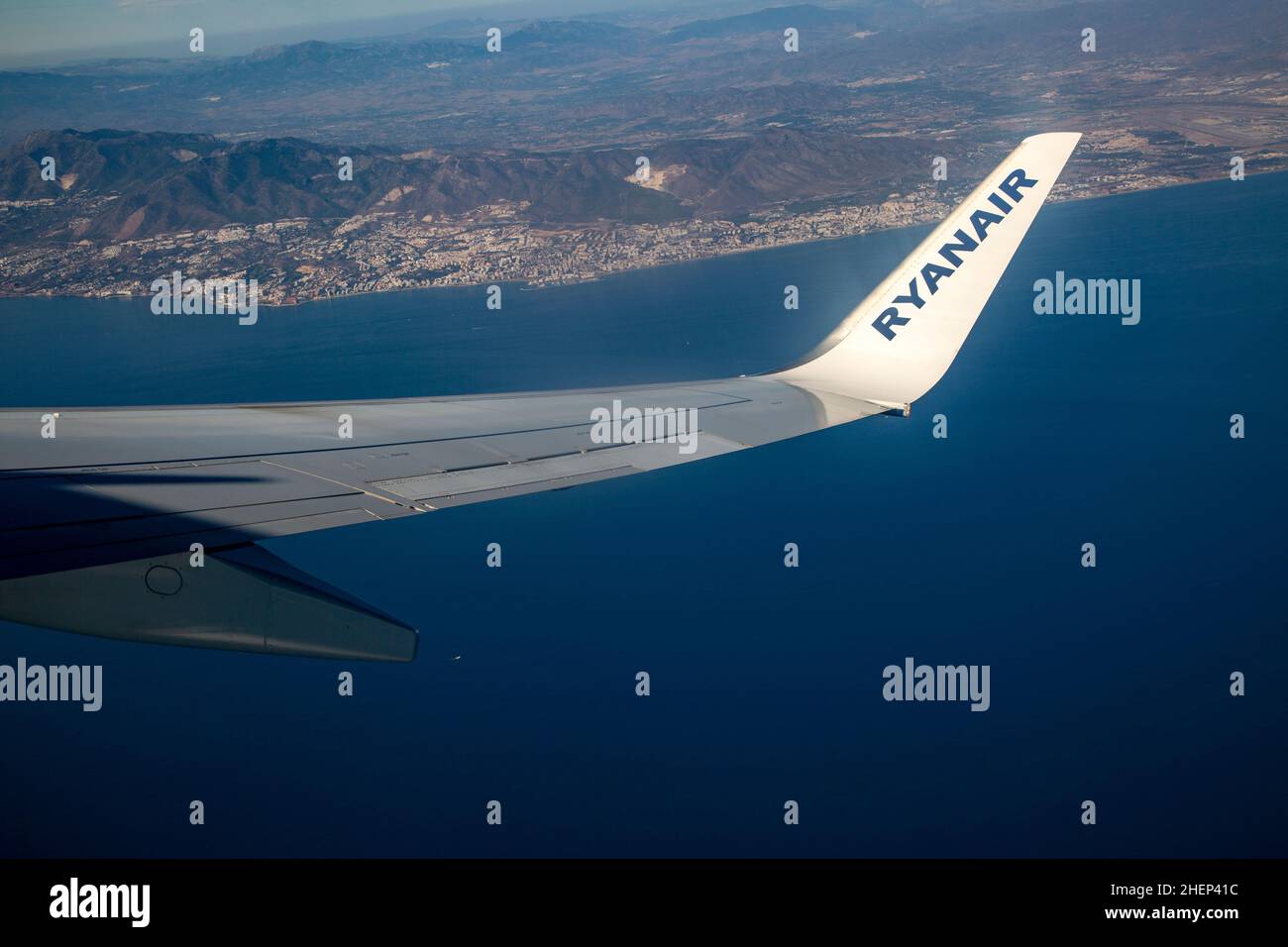 Wing of Ryanair aircraft above Mediterranean Sea over the Costa del Sol taking off from Malaga, Spain Stock Photo
