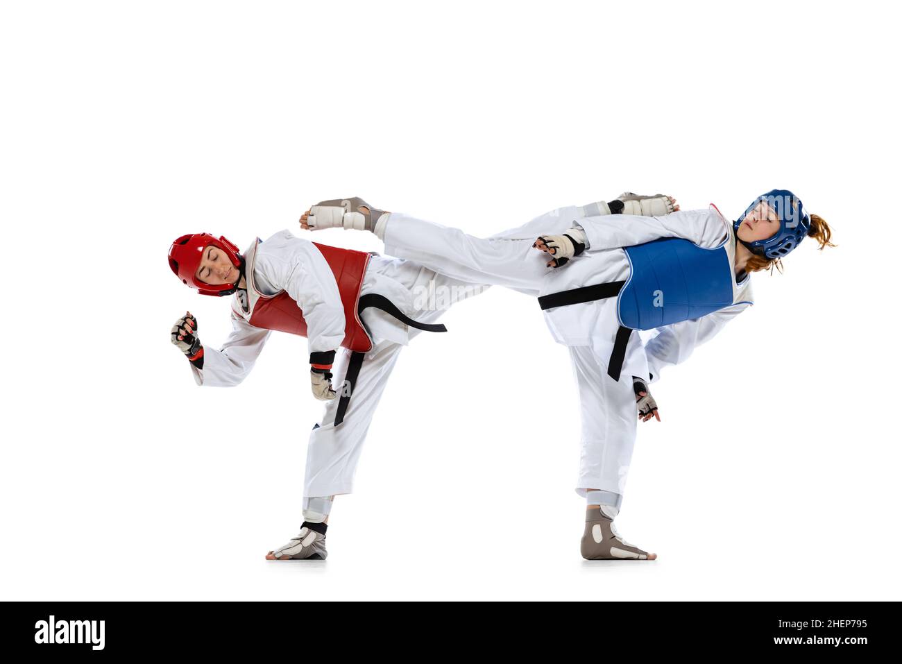 Portrait of two young women, taekwondo athletes practicing, fighting