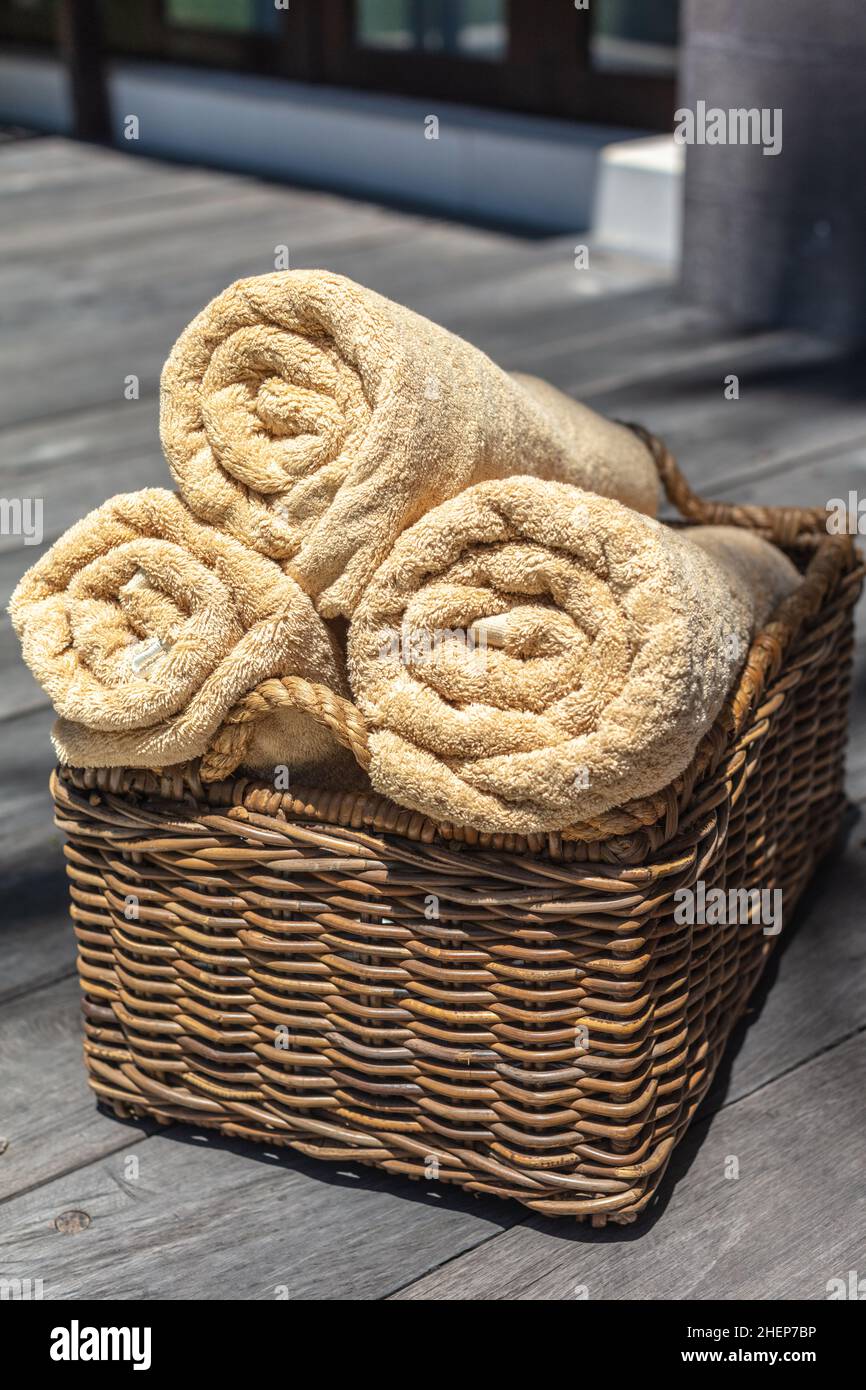 https://c8.alamy.com/comp/2HEP7BP/three-rolled-beige-color-towels-in-a-thatched-rattan-basket-vertical-image-2HEP7BP.jpg