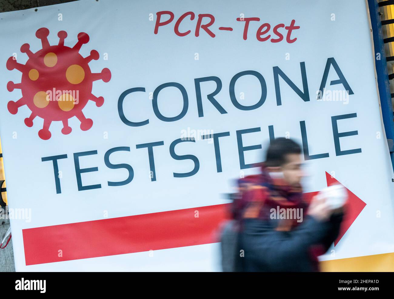 Munich, Germany. 12th Jan, 2022. A man walks past signs at the Deutsches Museum pointing to a Corona testing station. Credit: Peter Kneffel/dpa/Alamy Live News Stock Photo