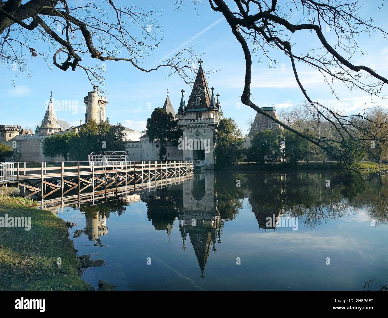Laxenburg, Austria - January 02, 2022: Castle pond with a walkway for visitors to Franzensburg Castle with reflection in the lake, a small ferry opera Stock Photo