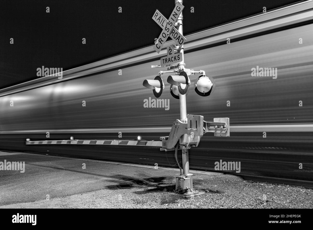 Railroad crossing by night with sign in kingman Stock Photo