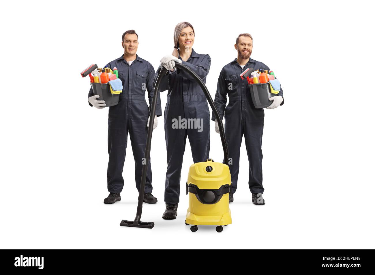 Team of professional cleaners in uniforms with a vacuum cleaner and ...