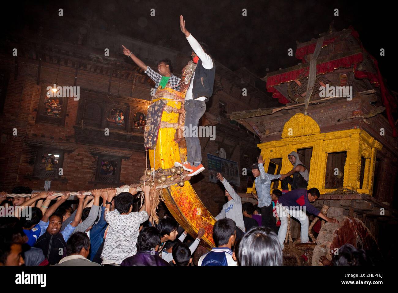 Residents hall a multi-tonne wooden chariot through the streets of UNESCO World Heritage city of Bhaktapur during Bisket Jatra: Nepali New Years. Stock Photo