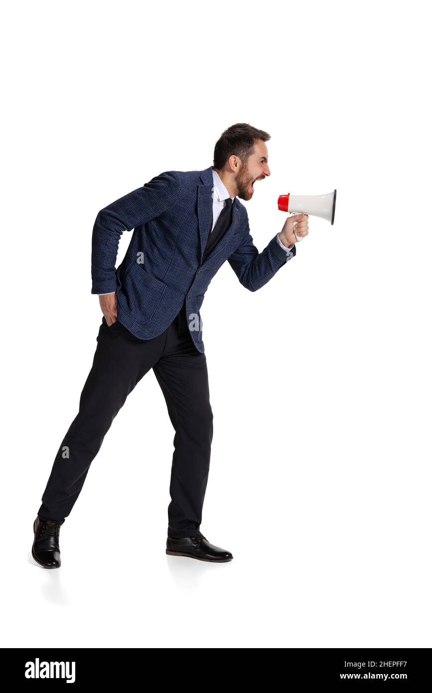 Full-length portrait of angry man, office worker shouting in megaphone  isolated over white background Stock Photo - Alamy