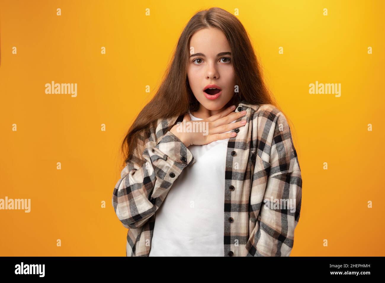 Surprised teen girl portrait against yellow background Stock Photo - Alamy