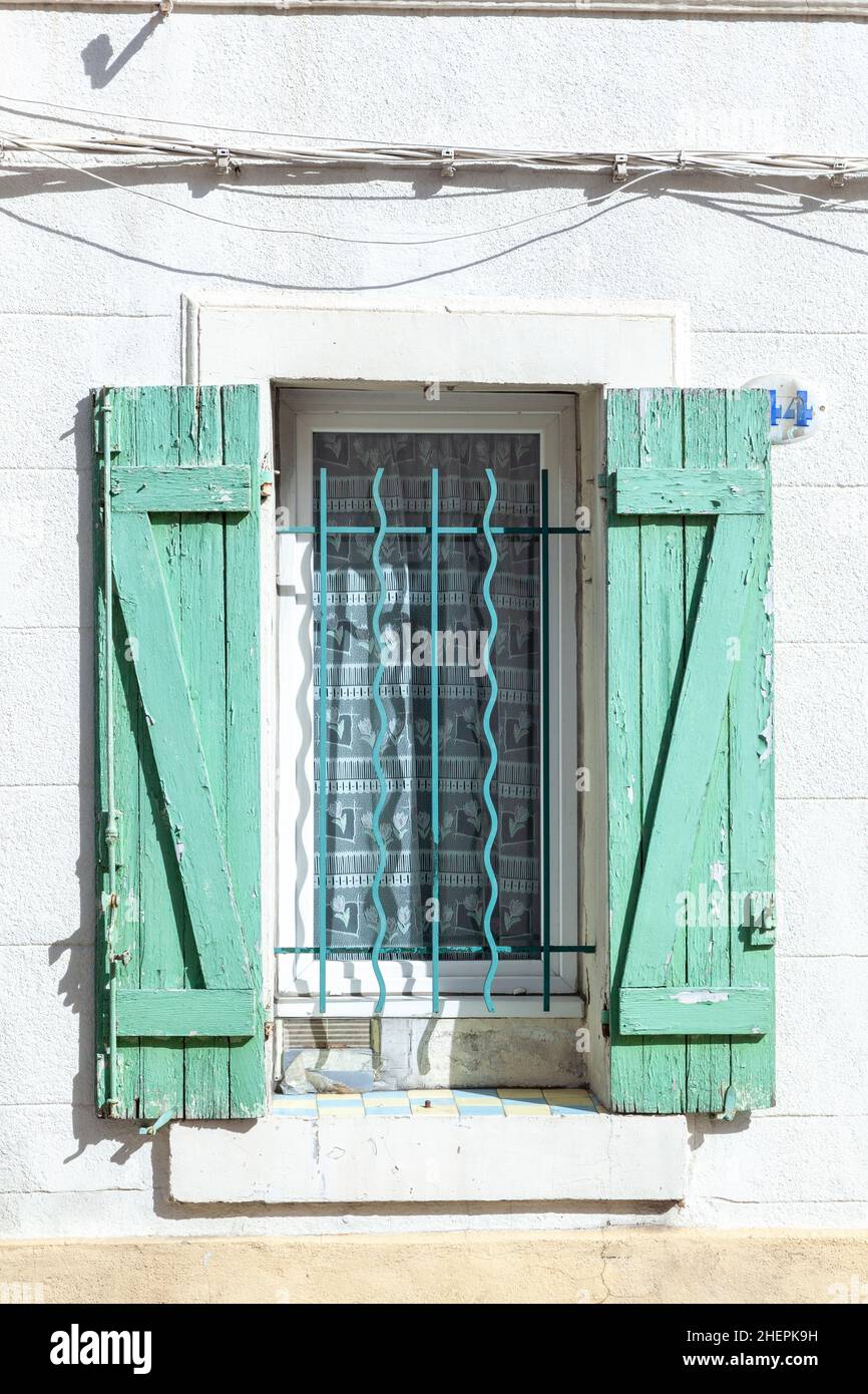 old house with wooden window shutter and peeling paint as background ...