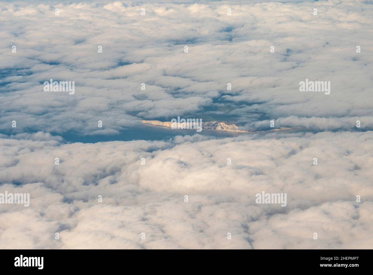 Glimpse of the white cliffs of the English south coast through a hole in the cloud whilst flying home form mainland Europe. Kent coast Stock Photo
