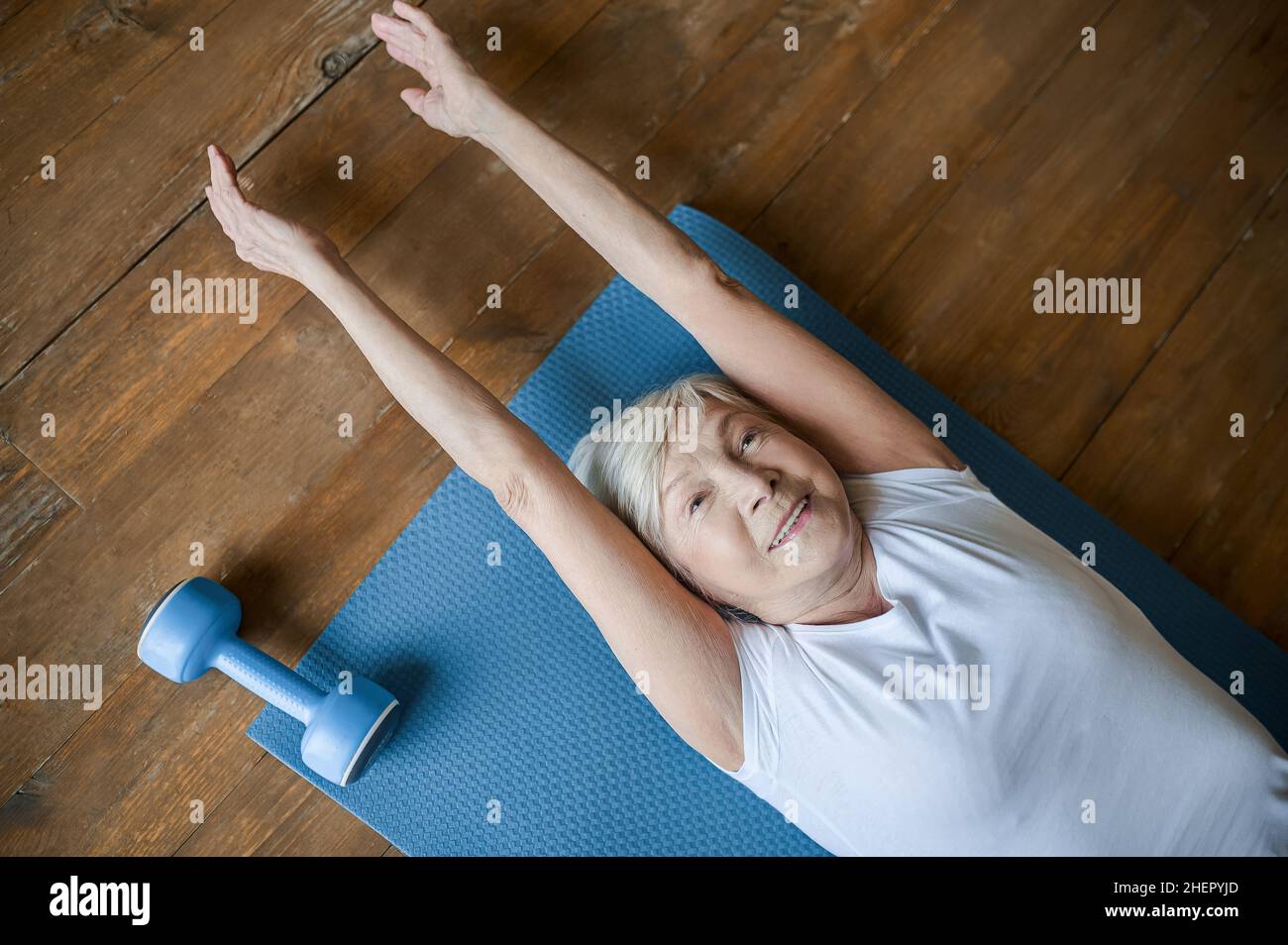 A senior woman laying on the floor and stretching Stock Photo Alamy