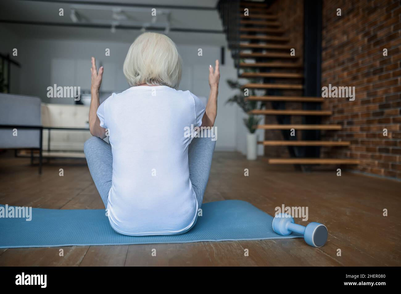 A woman doing exercises while sitting on the yoga mat Stock Photo - Alamy