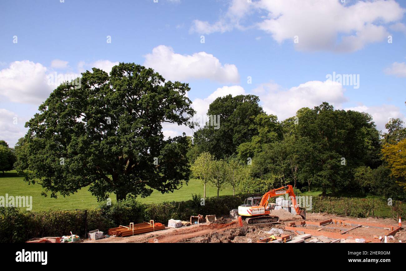 New housing development,building work beside greenfield site, established trees, grass,fields. Stock Photo