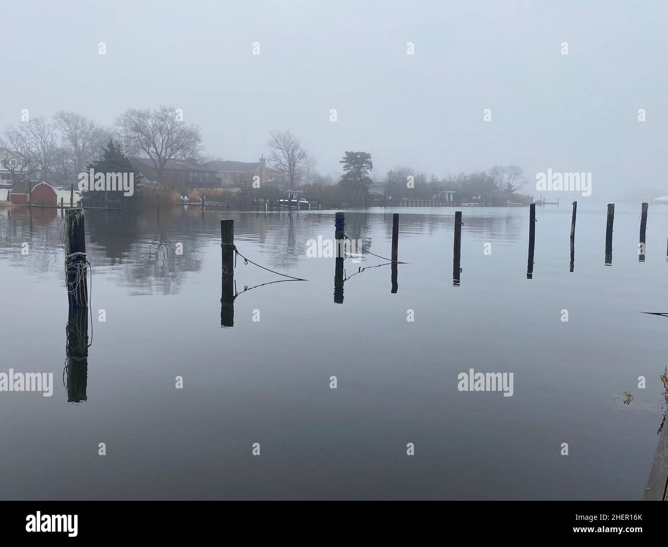 Marina looks spooky with fog covering the water on a warm January morning in Babylon Village on Long Island. Stock Photo